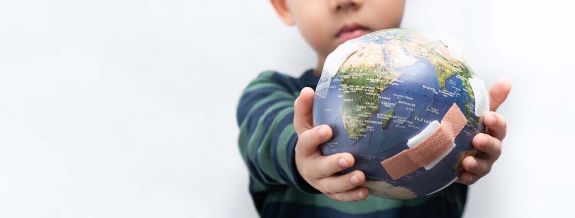 Closeup banner of a cute little asian boy a new generation presenting a damage globe full of bandages. Global warming, Climate change, Environmental problems. World pollution, Earth day, Net zero.